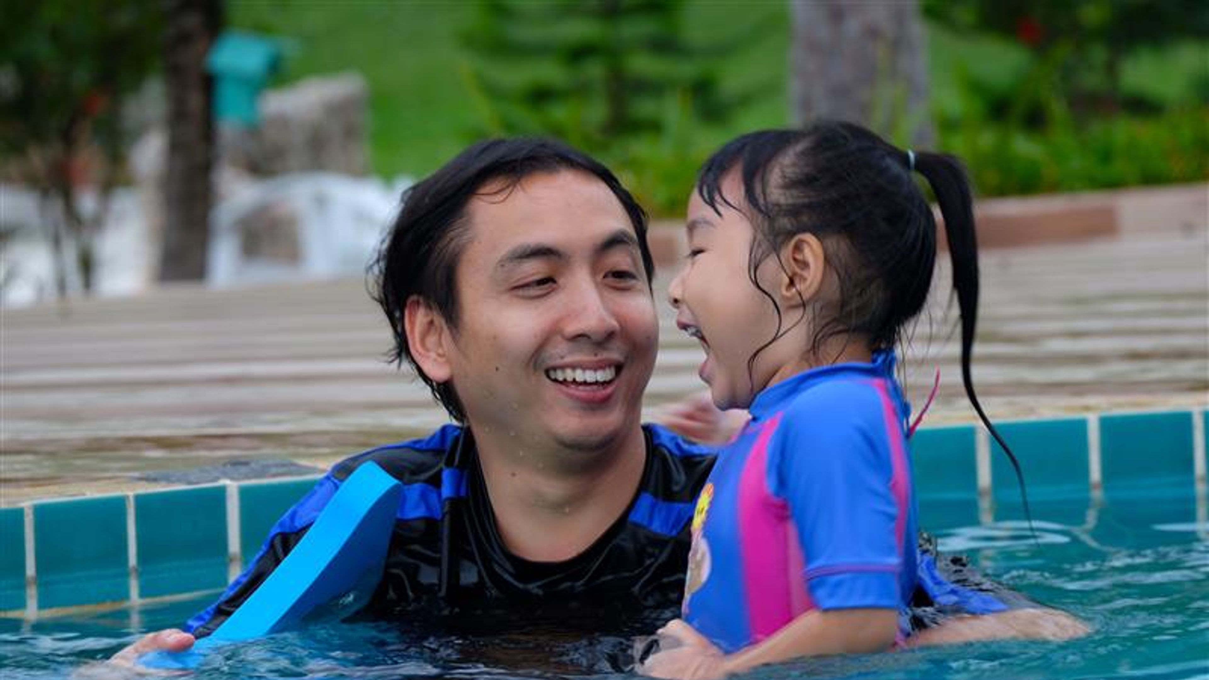 A father and a daughter enjoying in a pool 