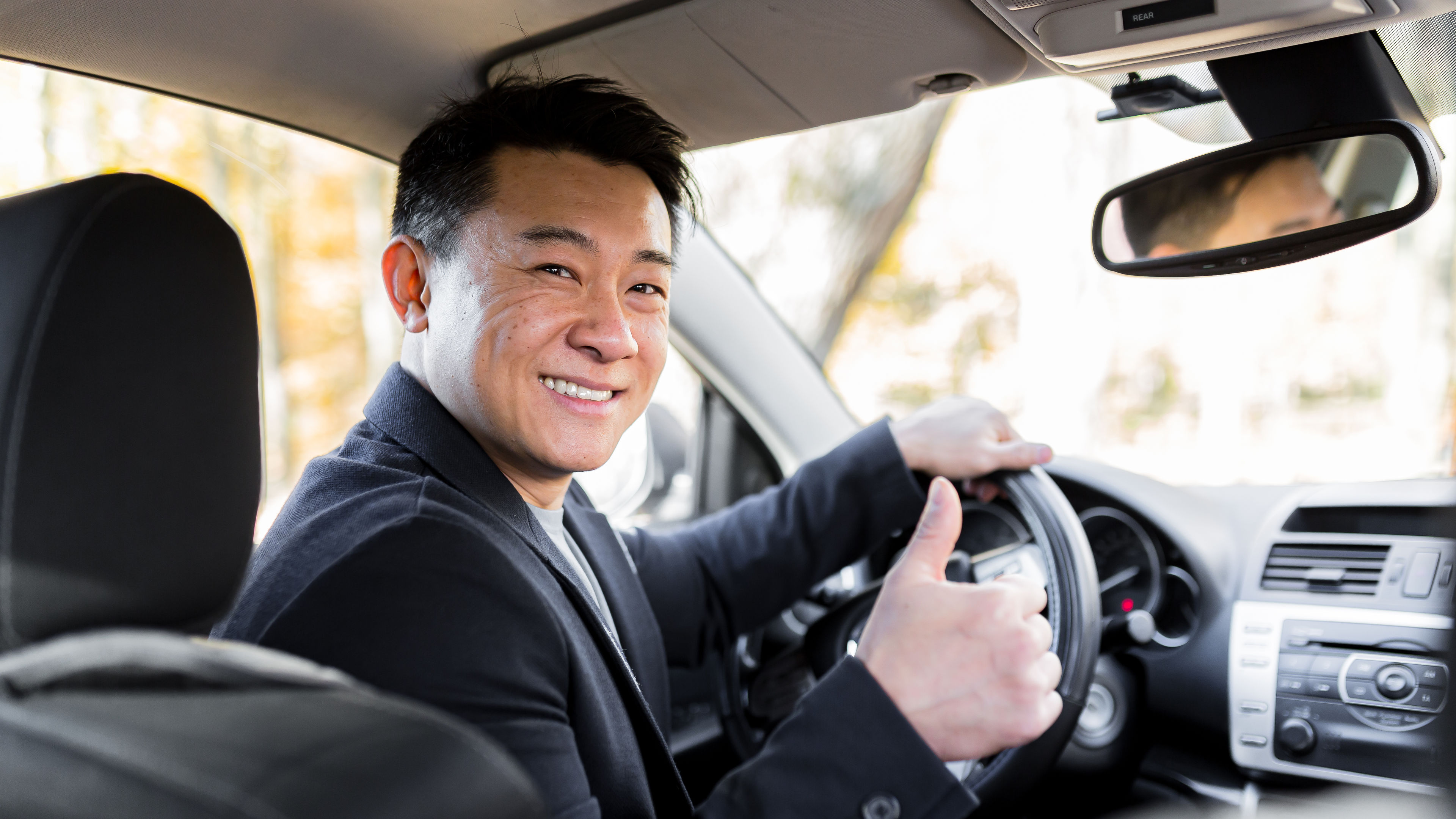 A man driving a car behind the wheel