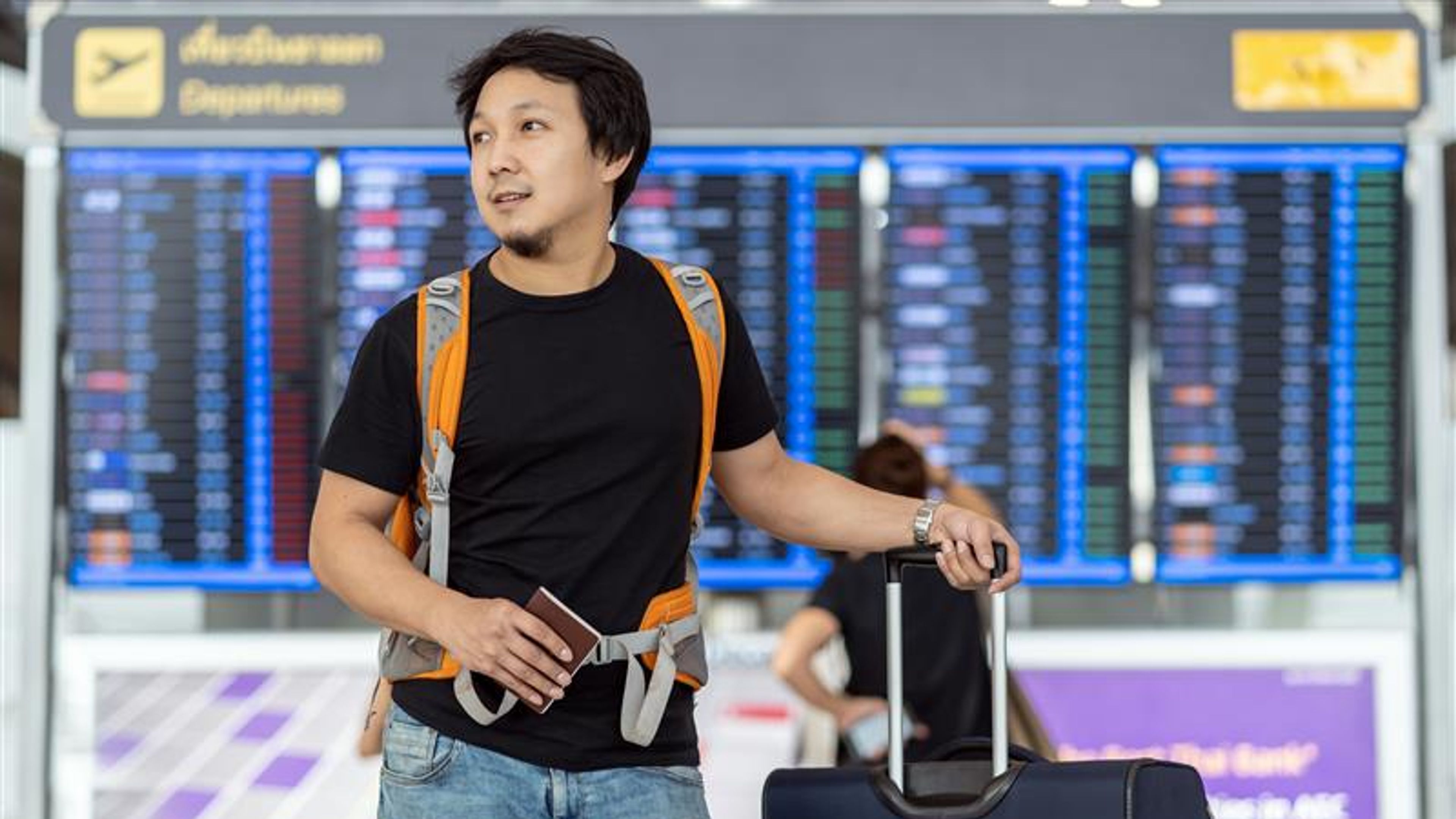 A man with luggage in an airport. 