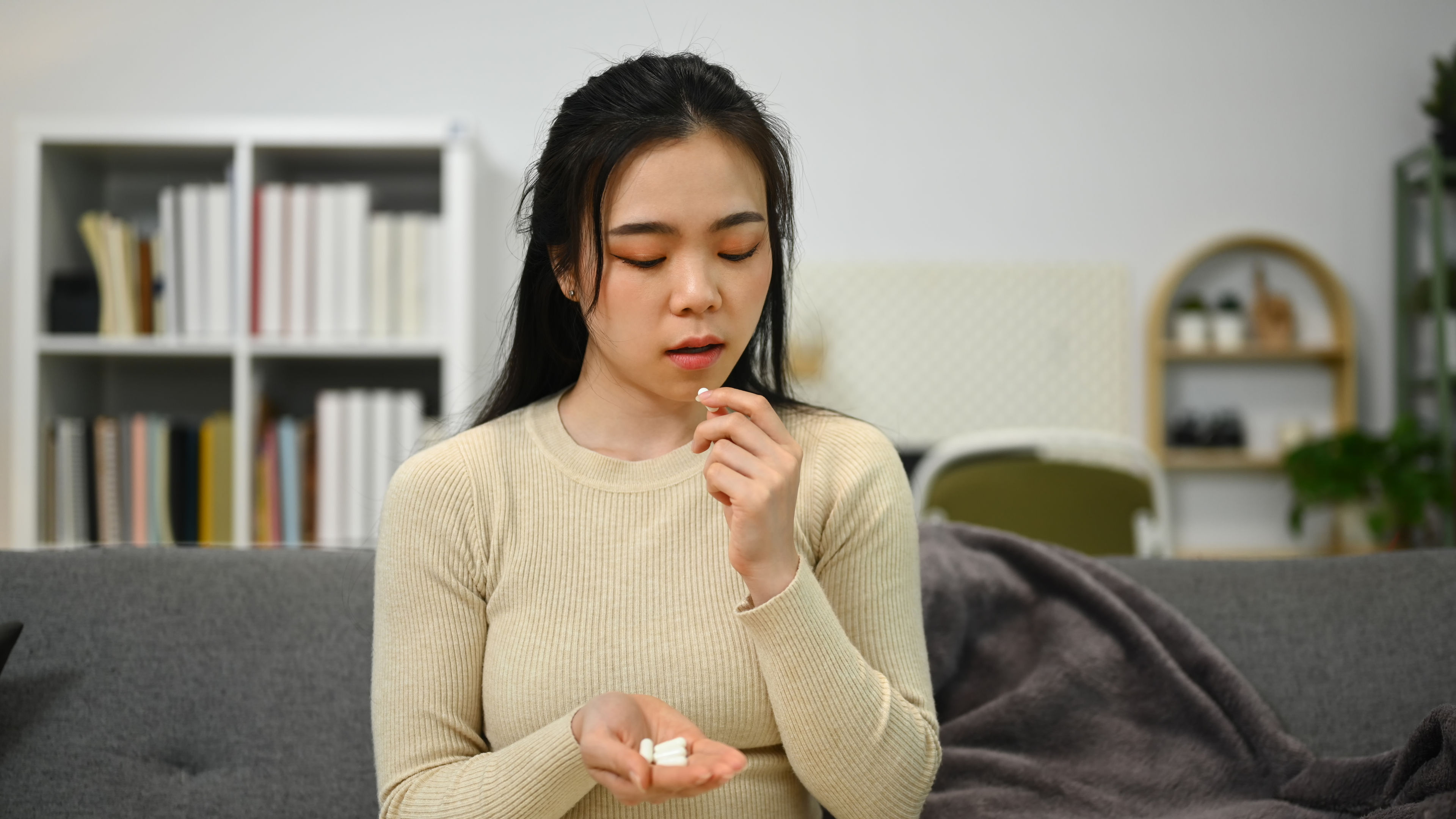 A woman eating some pills 