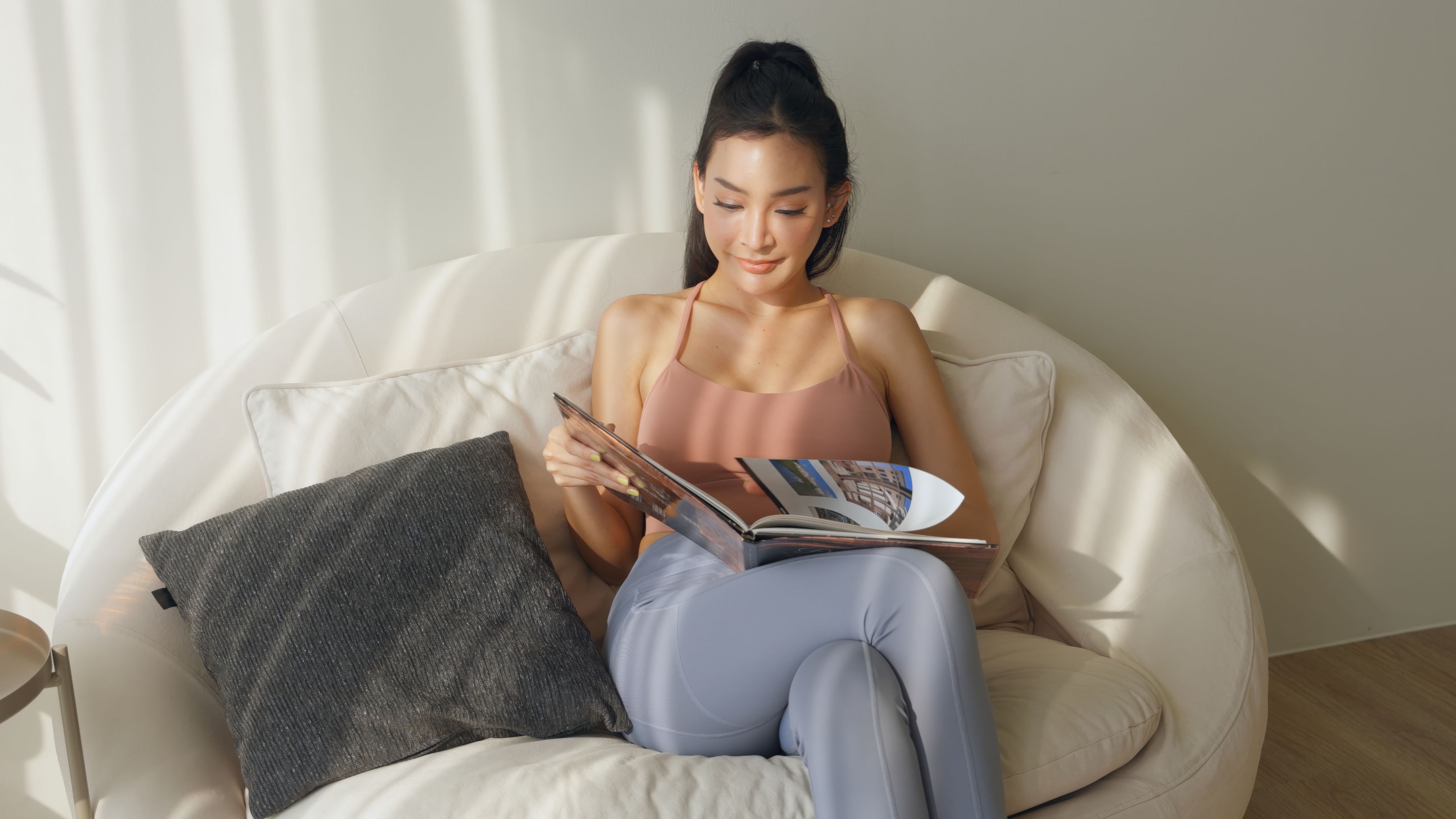 A woman sits comfortably on a couch.