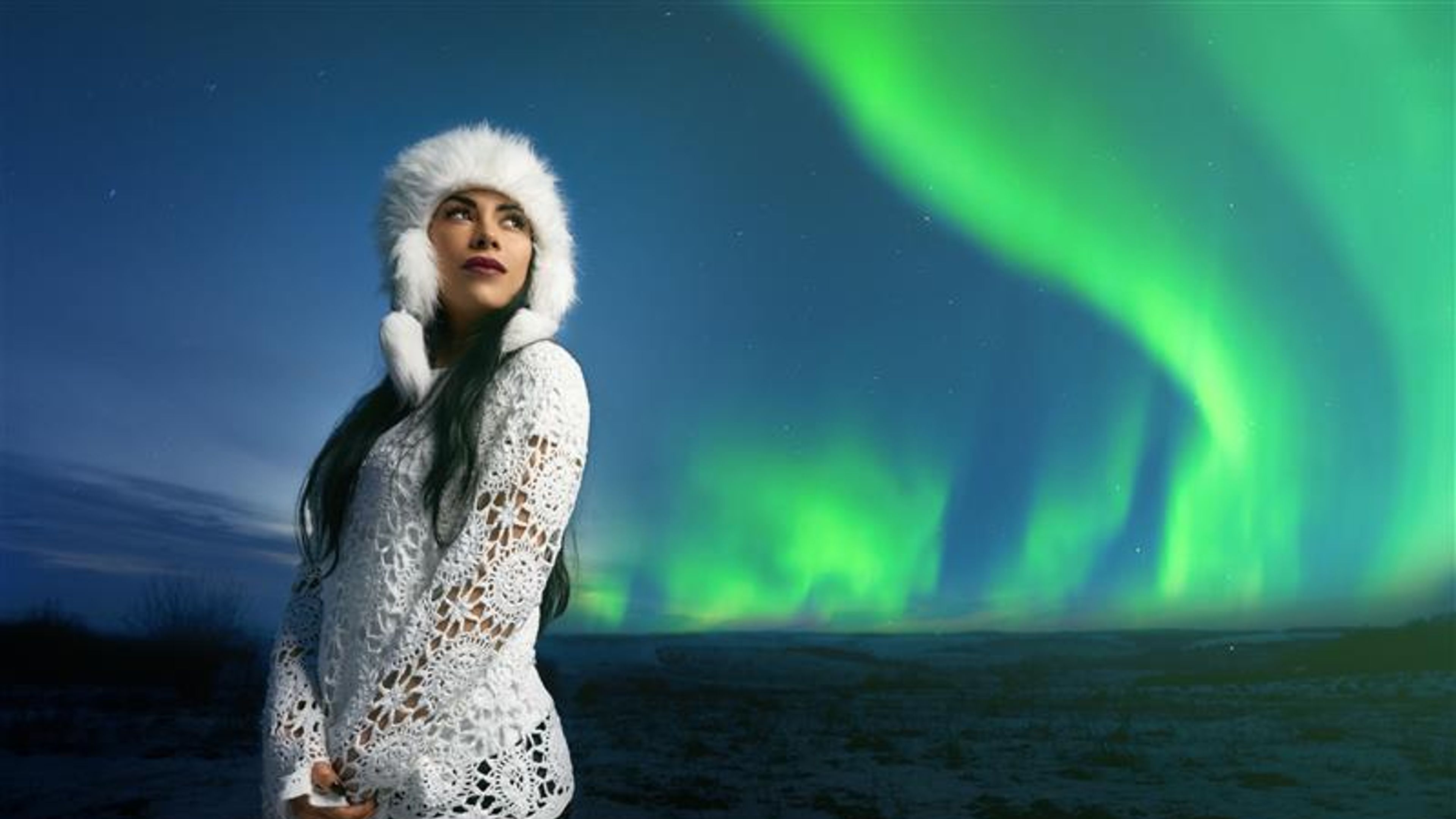 A woman with a background of northern lights.