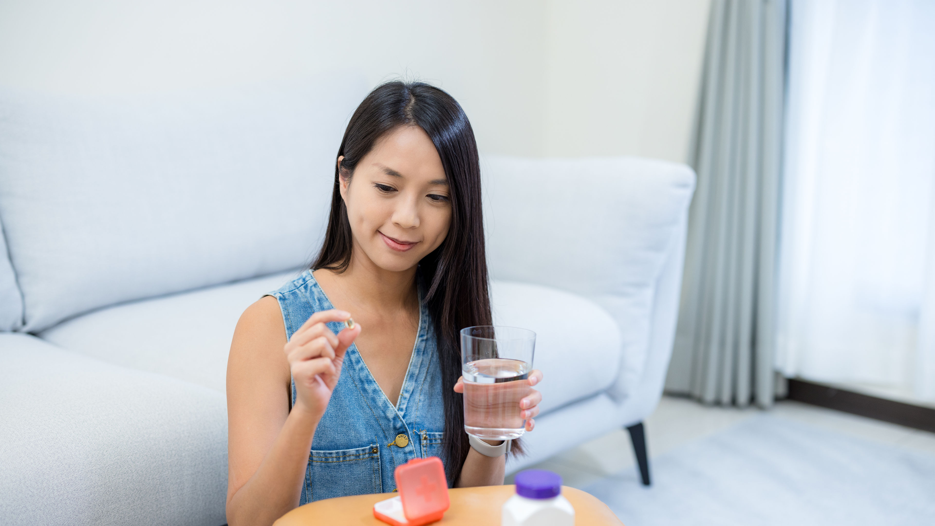 A woman with pills in hand. 