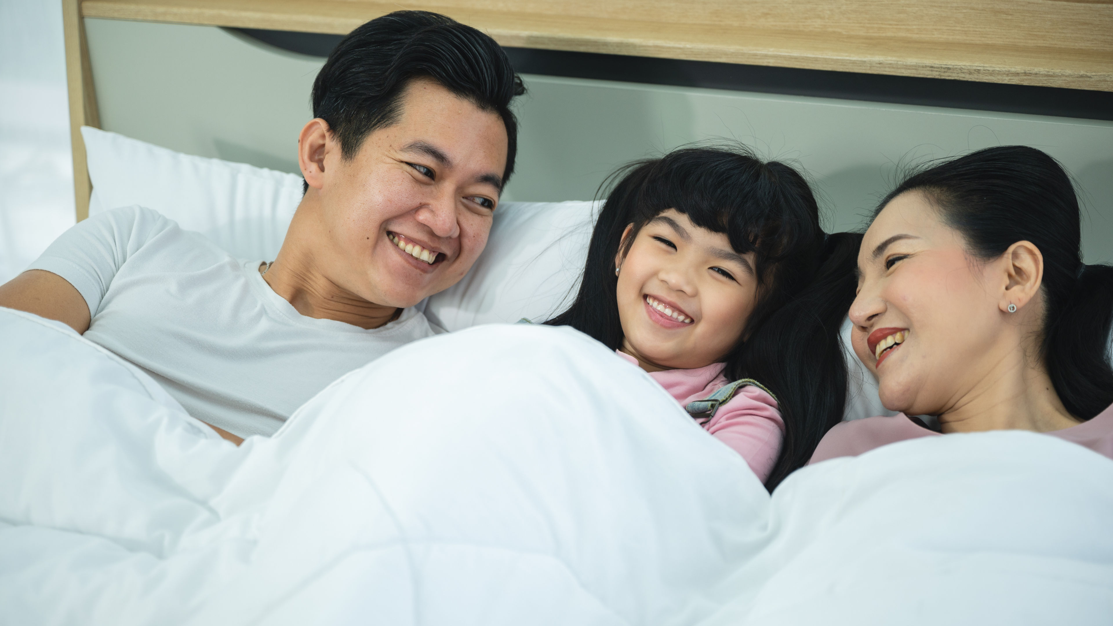 Cheerful family on a bed 