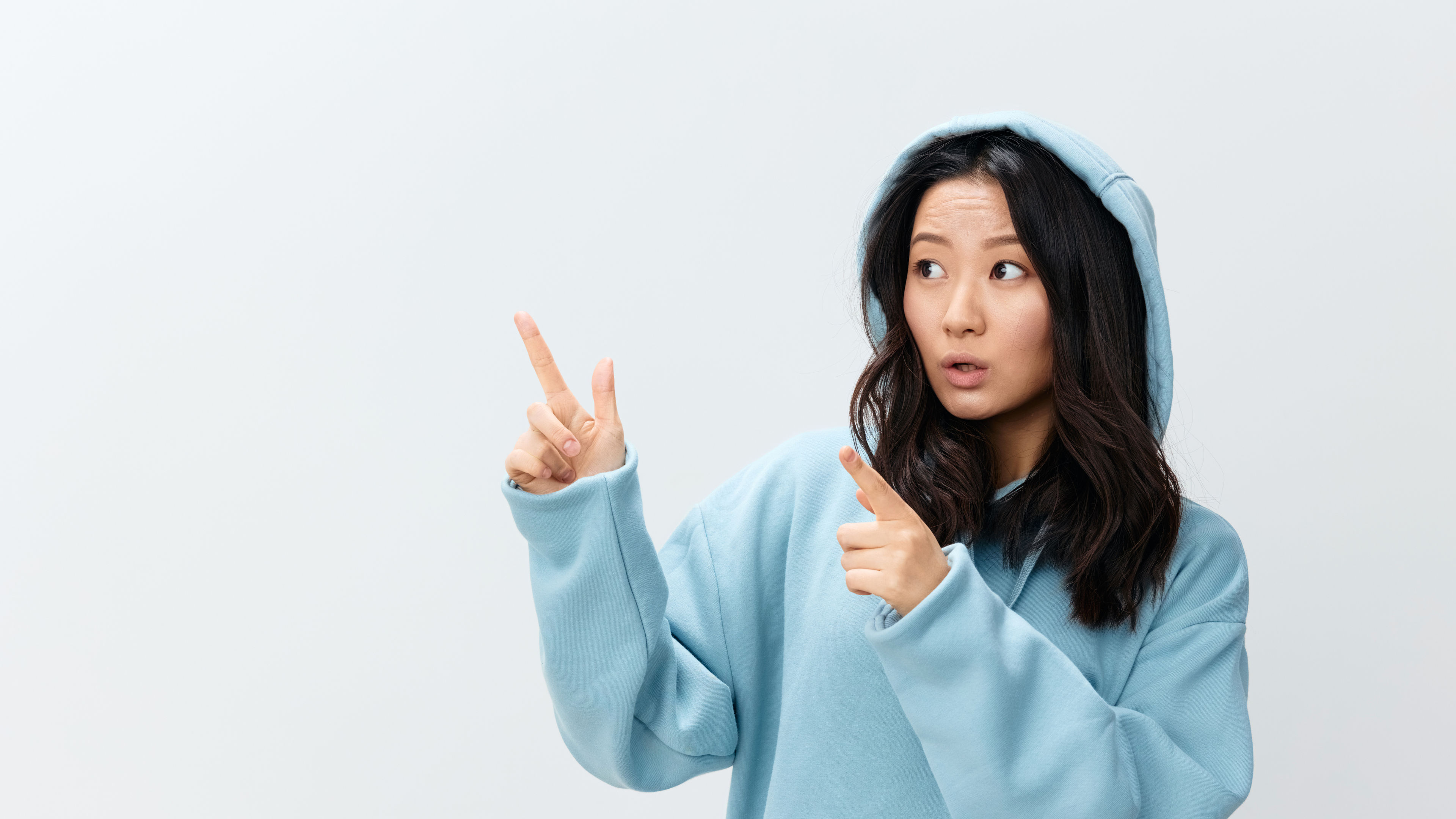 Cheerful happy cute Asian young female in blue hoodie sweatshirt