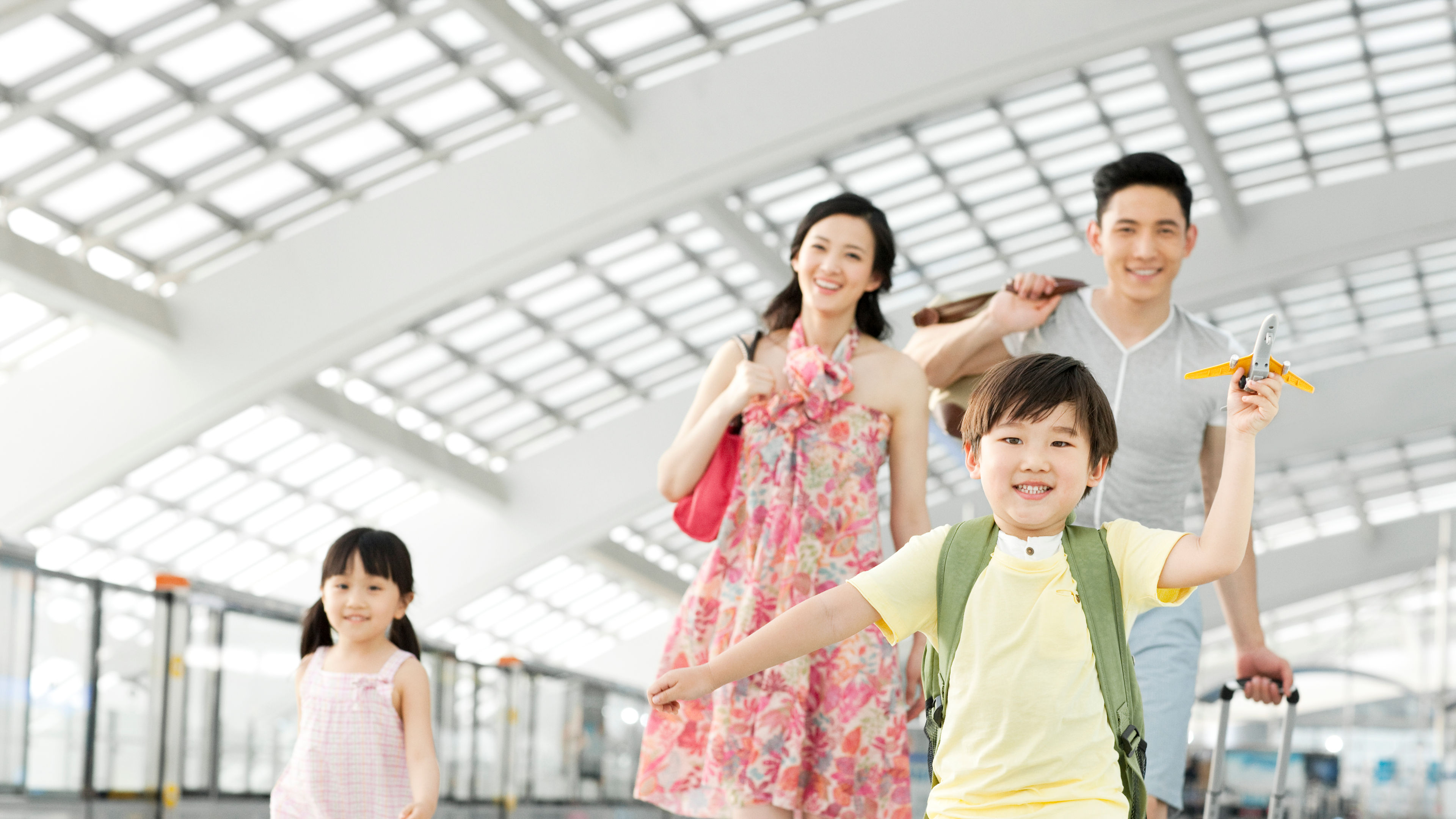 A happy family in an airport travelling with luggage  