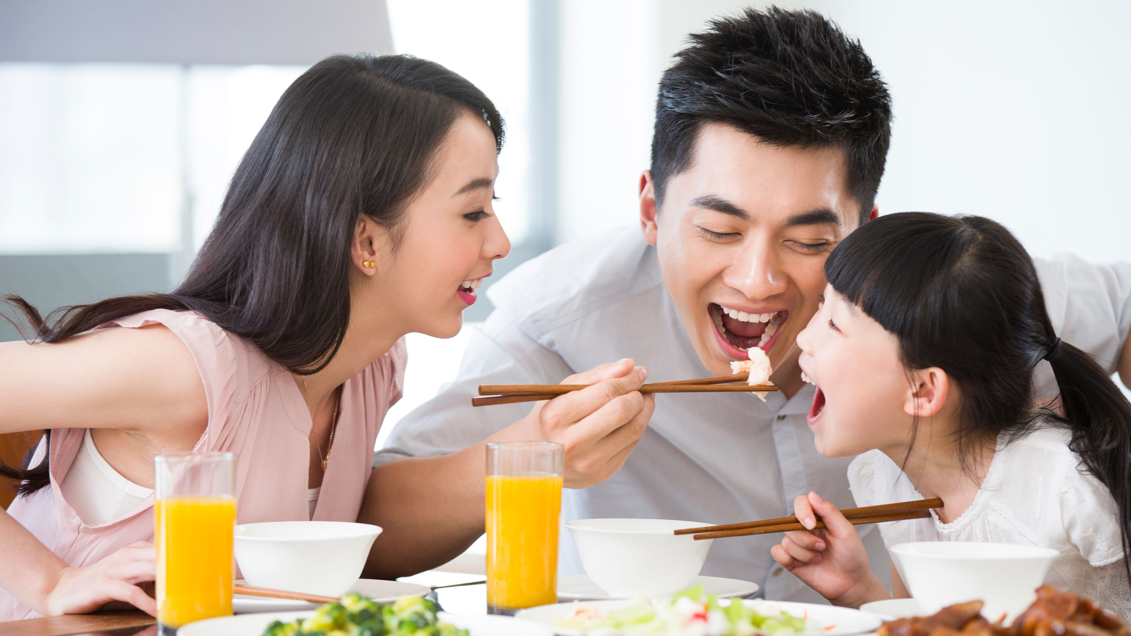 A happy family enjoys lunch together, sharing food, laughter, and warmth 