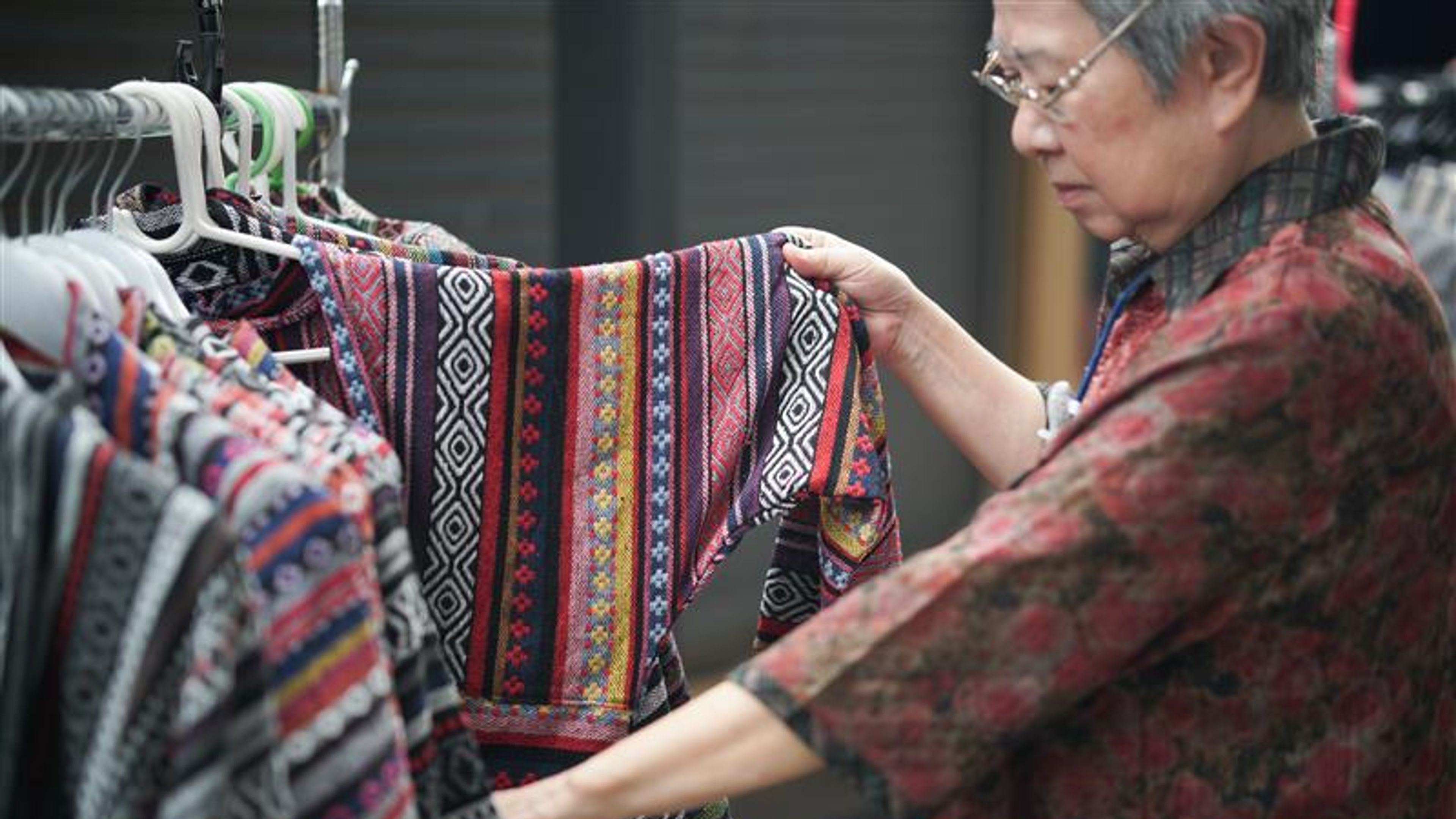 Old senior elder woman choosing clothes at store shop mall 
