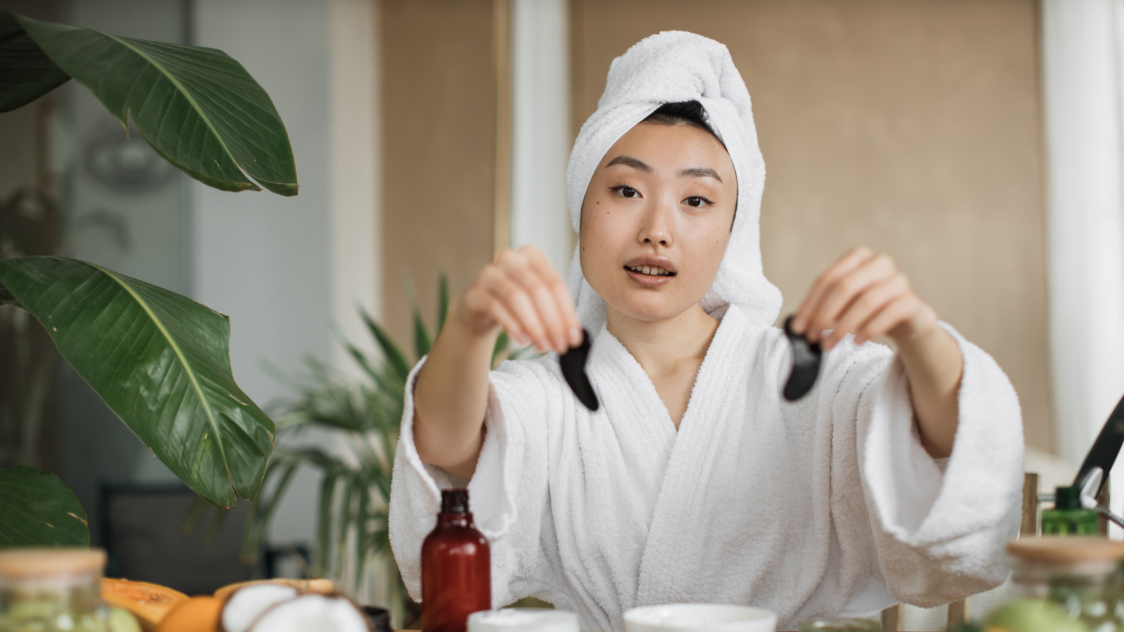 Smiling woman with eye patches wearing a hair towel. 