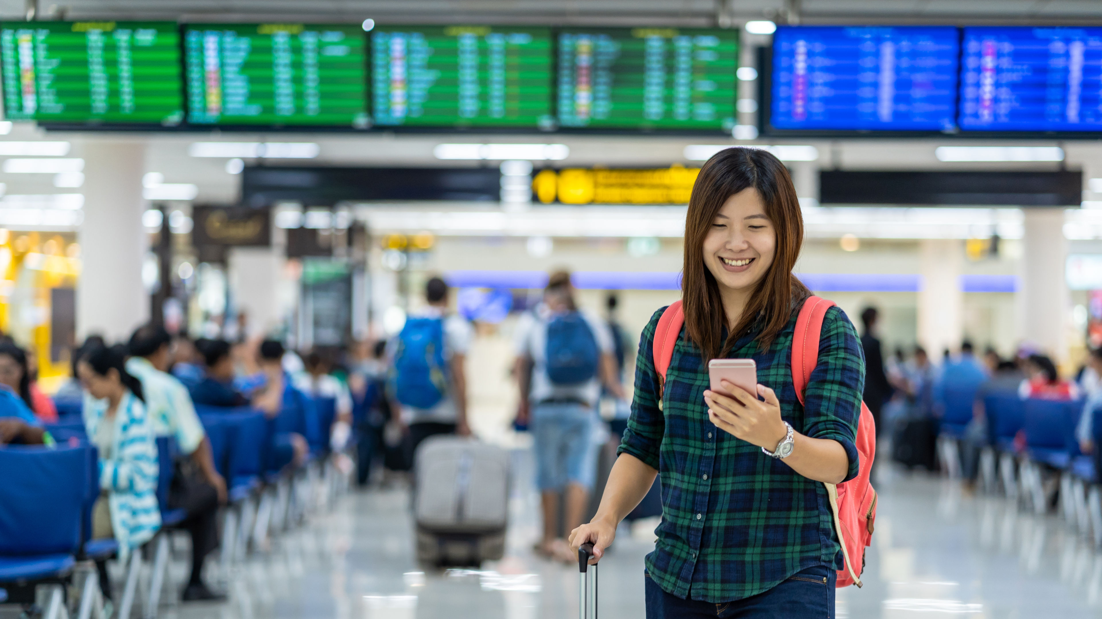 A traveller checks in at the airport, luggage tagged and boarding pass in hand. 