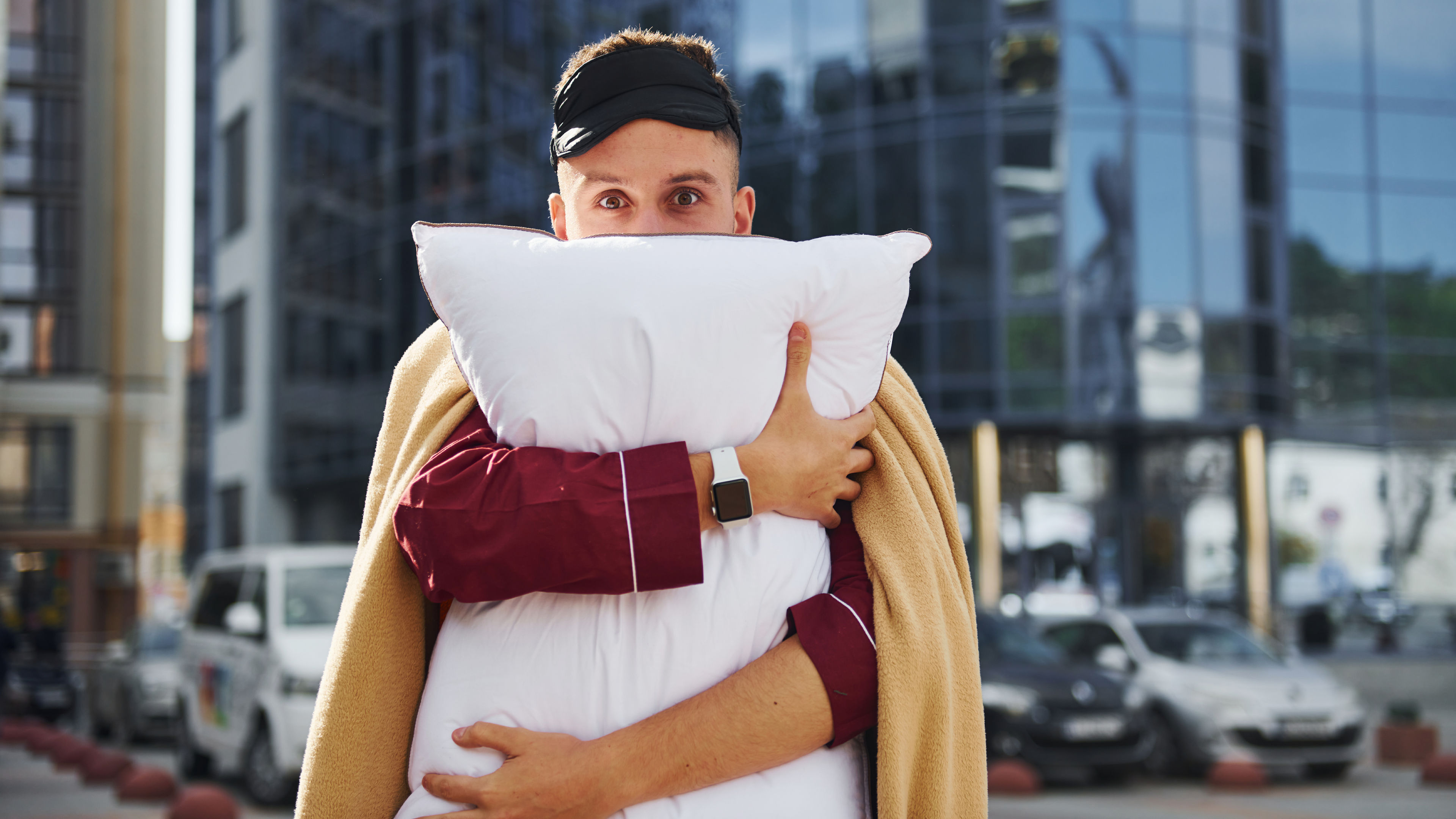 Young man embracing pillow