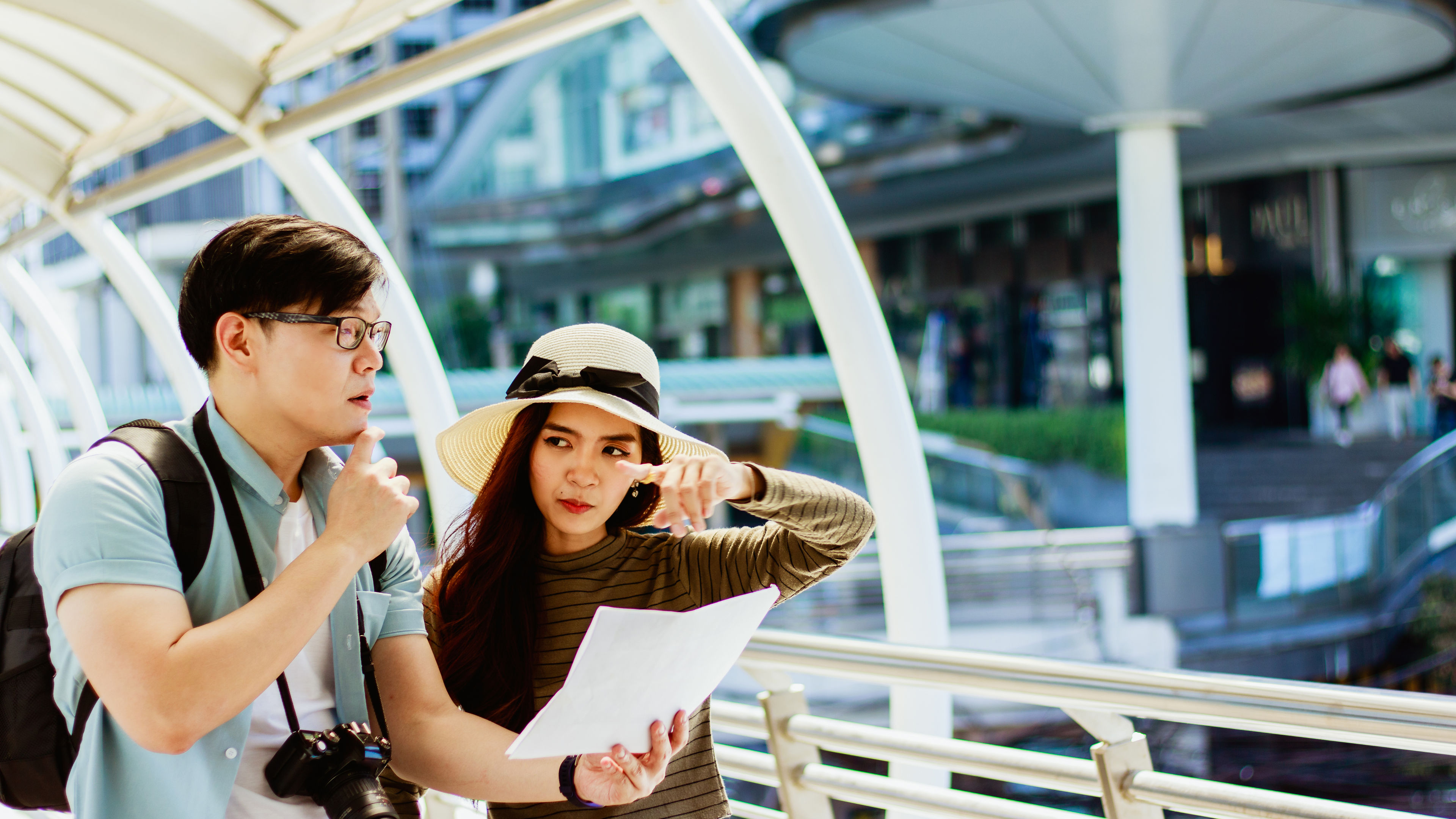 young Asian male and female tourists Viewing map of tourist attractions And consult about travel 