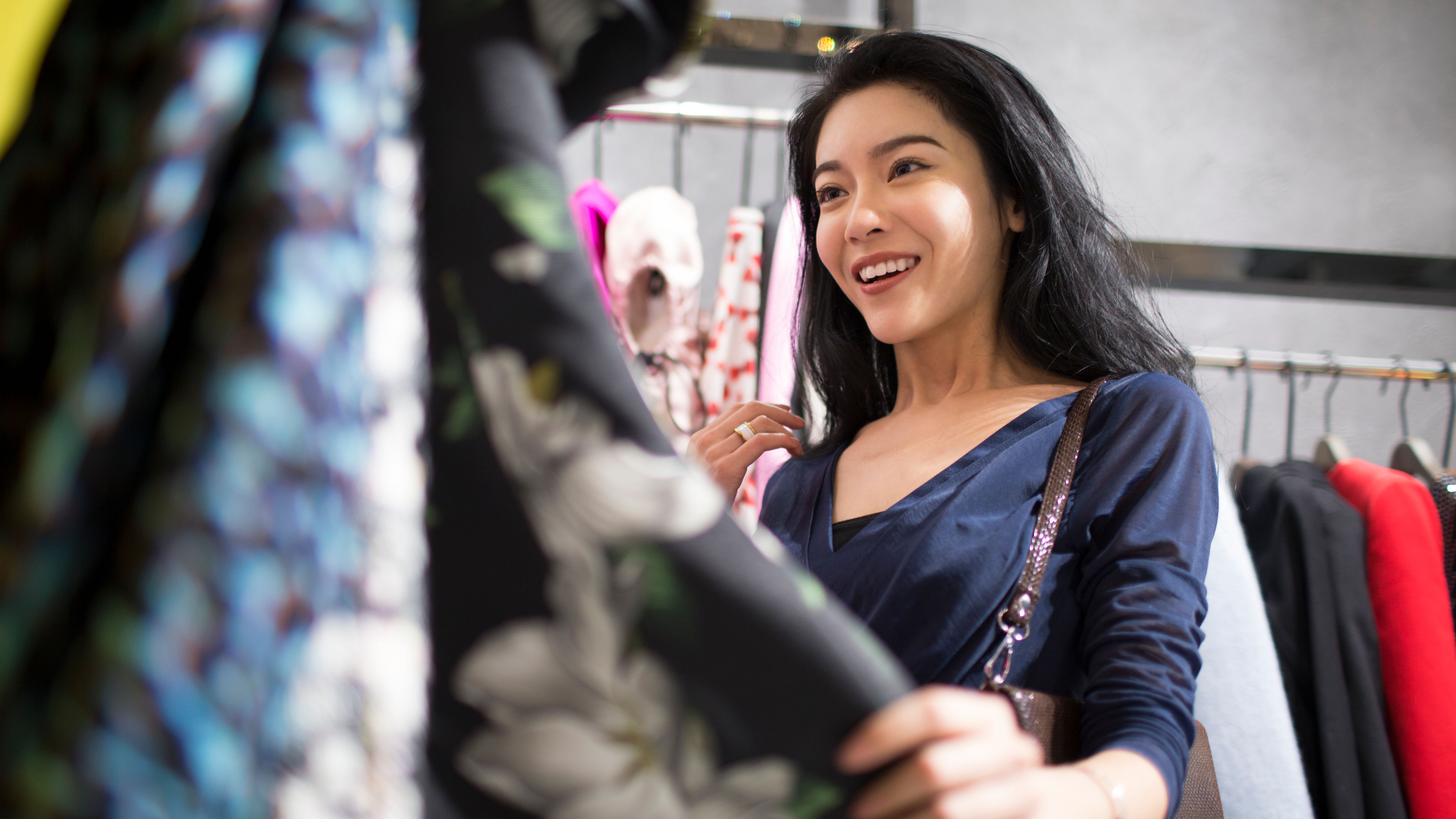 Excited young woman shopping for clothes 